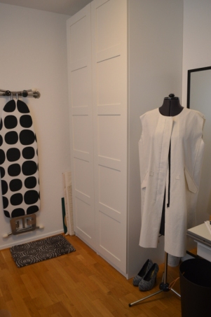 The hanger on the wall also works as storage for the ironing board